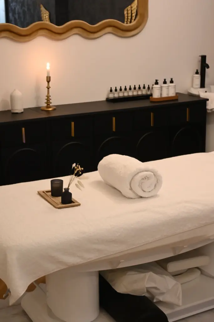 Stock photograph of a SPA treatment room with a massage table, rolled towel and candles